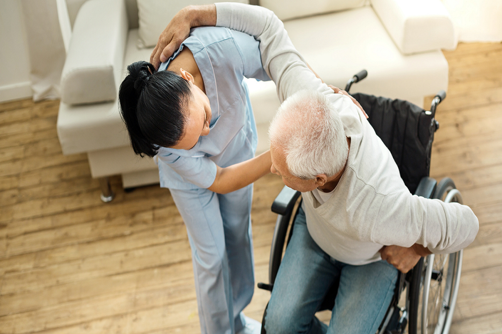 old woman in wheelchair doing rehab training with caregiver